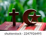 Small photo of Religious symbols : Muslim Crescent and Star with Quran, and Christan Cross with Bible. Interreligious or interfaith dialogue concept. 