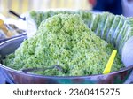 Small photo of Green rice flakes (Com in Vietnamese). Com is freshly harvested sticky sweet rice and is pounded and mixed with shredded fresh coconut rice. Delicious and nutritious street food