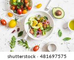 Fresh salad with tomatoes and avocado on a light background. Top view  