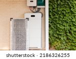 Electrical system for solar energy installation with solar panel, battery and inverter with plants on one side