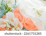 Pastel flowers with a draped, white wedding veil.