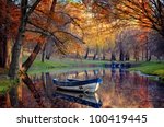 Colorful autumn landscape.Nature background.Boat on the lake in the autumnal forest