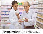 Small photo of Taking the questions out of medication. Shot of a young pharmacist helping an elderly customer.