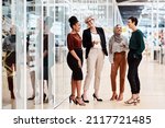 Female business people or Friends - Diverse Group of Females Only in a modern Office discussing and laughing. Multi ethnic natural group of business people with age diversity in a modern company