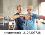 Small photo of Forget about age, its time to engage. Shot of a senior man working out with the help of a trainer.