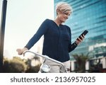 Small photo of Mobile tech is a godsend for entrepreneurs on the move. Shot of a mature businesswoman using a smartphone while traveling with a bicycle through the city.