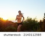 Small photo of Train like a beast, look like a beauty. Cropped shot of a young woman jogging outdoors.