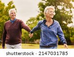 Small photo of Love keeps a marriage alive. Shot of a happy senior couple going for a walk in the park.