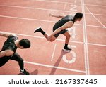 Hes stolen it. High angle shot of two handsome young male athletes crossing the finishing line during their race on a track.