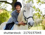 Small photo of There is nothing alive quite so beautiful as a horse. Shot of an attractive young woman standing with her horse in a forest.