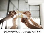 Business people hands with puzzle showing solution, problem solving and teamwork. Smart group or team activity completing, finishing a task project or assignment in difficult challenging work crisis