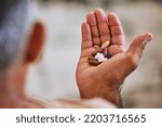 Small photo of Senior hand of man with pills, medicine or medication for disease, cancer or health at home. Wellness, healthcare or sick elderly retired person with medical drugs, aspirin or antibiotics in palm.