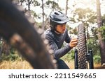 Cycling, adventure trail and bike repair, man fix wheel in forest. Nature, mountain biking and cyclist, outdoor cycle maintenance in Australia. Bicycle ride, dirt path and biker stop for tyre change.