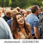 Small photo of The most fun ever. Portrait of an attractive woman laughing in a crowd at a music festival.