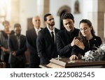 Small photo of Death, funeral and family touching coffin in a church, sad and unhappy while gathering to say farewell. Church service casket and sad man and woman looking upset while greeting, goodbye and rip