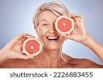 Grapefruit, portrait of happy senior woman in studio or natural skincare product for vegetarian lifestyle. Detox diet for retirement, elderly healthcare nutritionist on gray background or clean face