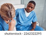 Small photo of Doctors, nurses or healthcare team with stress and depression talking about empathy. Black man support crying woman in hospital with mental health, depression and anxiety for crisis fail or mistake