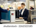 Small photo of Airport, check in desk and woman typing for security, identity and travel documents for border immigration service. Concierge, customer service and help for global transportation with pc on table