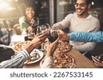 Small photo of Thank you all for coming. Shot of a group of cheerful young friends having a celebratory toast with wine at dinner inside of a restaurant.