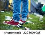 Small photo of Litter all around. Closeup of someones feet inbetween litter.