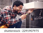 Small photo of Happy, man or plumber fixing a sink with smile in maintenance or installation in home repairs. African handyman or worker with plumbing tools to fix water pipes or house basin in renovation project