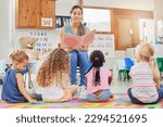 Everyone loves story time. Shot of a young woman reading to her preschool students.