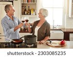 Cheers, happy or old couple cooking food for a healthy vegan diet together with love in retirement at home. Smile, toast or senior woman drinking wine in kitchen to celebrate with husband at dinner