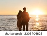 Sunset, beach and back of couple hug in evening on holiday, summer vacation and weekend by ocean. Nature, love and man and woman embrace, hugging and relax for bonding, quality time and peace by sea