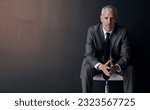Small photo of Mock up, chair and serious portrait of lawyer, attorney or businessman with confidence on dark background in studio space. Boss, ceo or business owner, proud senior executive director at law firm.