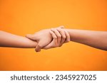 Holding hands, studio and closeup for support, help and care for teamwork by orange background. People, friends and together for solidarity, link and connection with synergy, partnership and strong