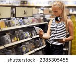 Woman, customer or shopping for music disc, cd or album in store playlist selection, decision and choice. Thinking student, person and musician with headphones reading multimedia information by shelf