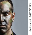 Small photo of Man, portrait and soldier with face paint for camouflage, military war or battle on a gray studio background. Closeup of male person, army or commander with color dye in undercover disguise on mockup