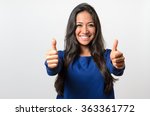 Enthusiastic motivated attractive young woman giving a thumbs up gesture of approval and success with a beaming smile