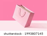 Small photo of Paper shopping bag on pink background. Shopping sale delivery concept