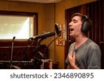 Small photo of Professional singer in recording studio. Singer recording a single in the studio. Happy man singing. Professional singer. Copy space
