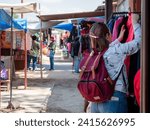 Small photo of Tourist shopping in the small streets of Purmamarca, Jujuy, Argentina. Shopping through the colorful streets of Purmamarca, Argentina. Beautiful and colorful streets of northern Argentina