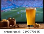 Small photo of viewer watching soccer drinking beer and eating cheese and peanuts