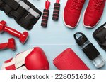Red sport equipment on wooden background, top view