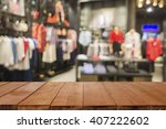 Empty brown wooden table and De focused/blurry background of Sports clothing store with bokeh image luxury and fashionable brand,can be used for montage or display your products