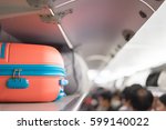 Carry-on luggage on the top shelf  over head on airplane, passenger put bag cabin compartment air craft  business class,vintage color,copy space