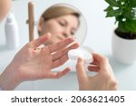 A woman holds a contact lens on her finger