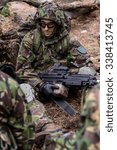 Small photo of Soldier in uniform and helmet with mashine gun in hands resting on battlefield in forest/British machine gunner in forest