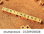 Small photo of CONTINGENCY word text from wooden cube block letters on braided rattan mats background. Contingency is something that depends on something else in order to happen.