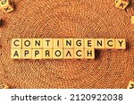 Small photo of CONTINGENCY APPROACH word text from wooden cube block letters. Contingency approach is a management theory that suggests the most appropriate style of management is dependent on the situation.