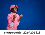 Small photo of overexcited young black female teenage female entrepreneur with both arms raised at shoulder level while smiling looking away. Joyful gesture of young black female worker.