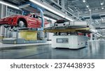 Small photo of Autonomous AGV Transports Batteries on EV Production Line on Advanced Bright Smart Factory. Performance Electric Car Manufacturing. Car Batteries being Attached to Electric Vehicles on Assembly line