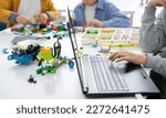 Small photo of Robotics programming class. Children construct and code Robot. STEM education using constructor blocks and laptop, remote control joystick. Technology educational development for school kids