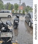 Small photo of YOGYAKARTA, INDONESIA - JANUARY 17, 2024: Rainy atmosphere at Indomart in front of Dr. zap Yogyakarta eyes.