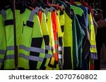 Selective blur on high visibility safety coats and jackets, personal protective equipments, for sale outside, fluorescent colors. These coats are made to be visible on workplace in any condition. 
