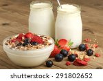 yogurt with fruit and mÃ¼sli on wooden background
